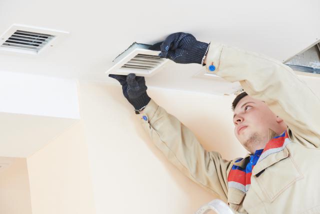 air conditioner repair serviceman checking the vents